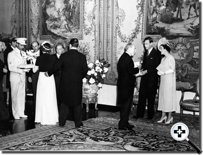 James Russel Barnes, Jr. making a floral presentation while the King and Queen of England are being greeted on the right